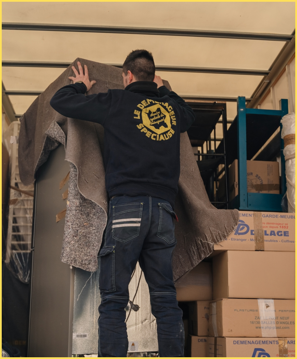 Déménageur protégeant un meuble dans un camion